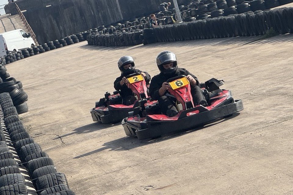 Drivers in helmets racing wheel to wheel at Formula Kart Blackpool