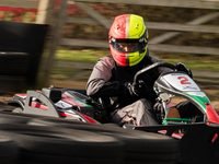A driver in a red and yellow helmet racing kart number 2 at South Coast Karting