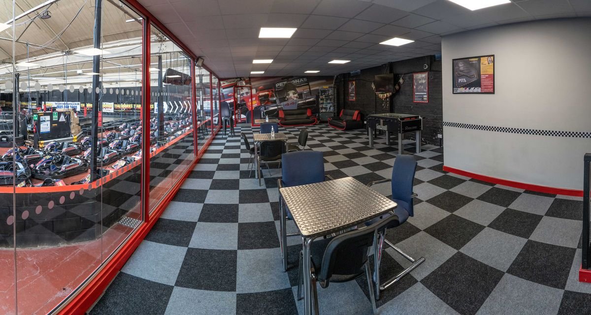 The viewing area and cafe at Teamworks Karting Letchworth, looking through the glass to the kart fleet in the pit lane